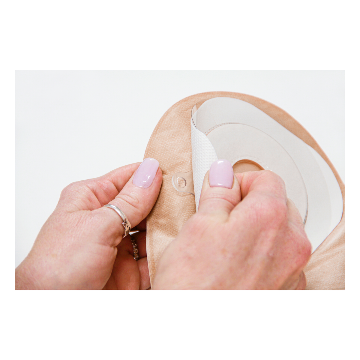 Hands preparing the ConvaTec Esteem+ one-piece pouch skin barrier