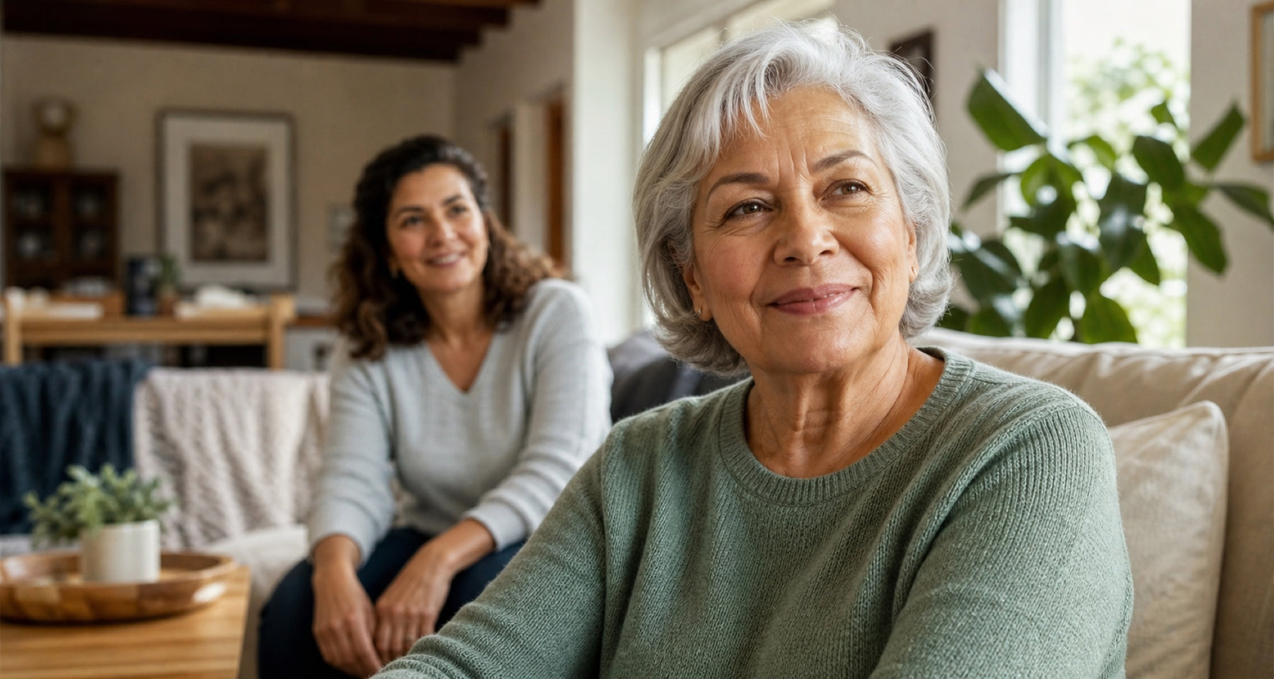 Older woman at home with a family caregiver nearby